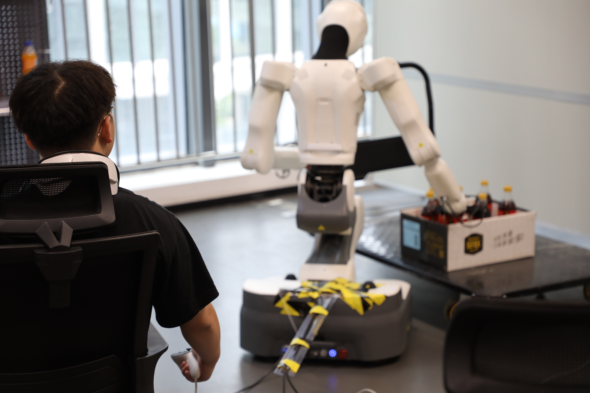 Operator training a humanoid robot to pick items from a crate